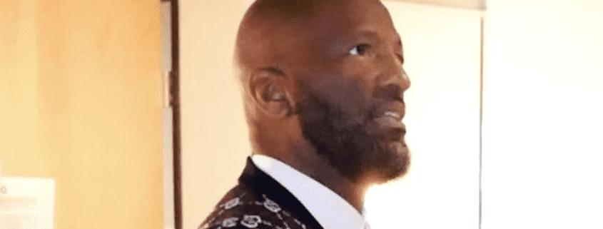 Man with beard in formal patterned suit.